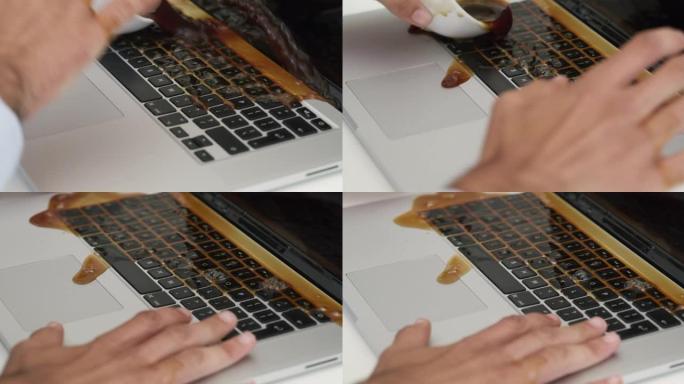 4k视频片段，一个无法识别的商人坐在办公室里，在笔记本电脑上洒了一杯咖啡