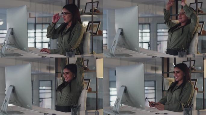 4k视频片段，一位迷人的年轻女商人独自坐在办公室里，在使用计算机时感到放心