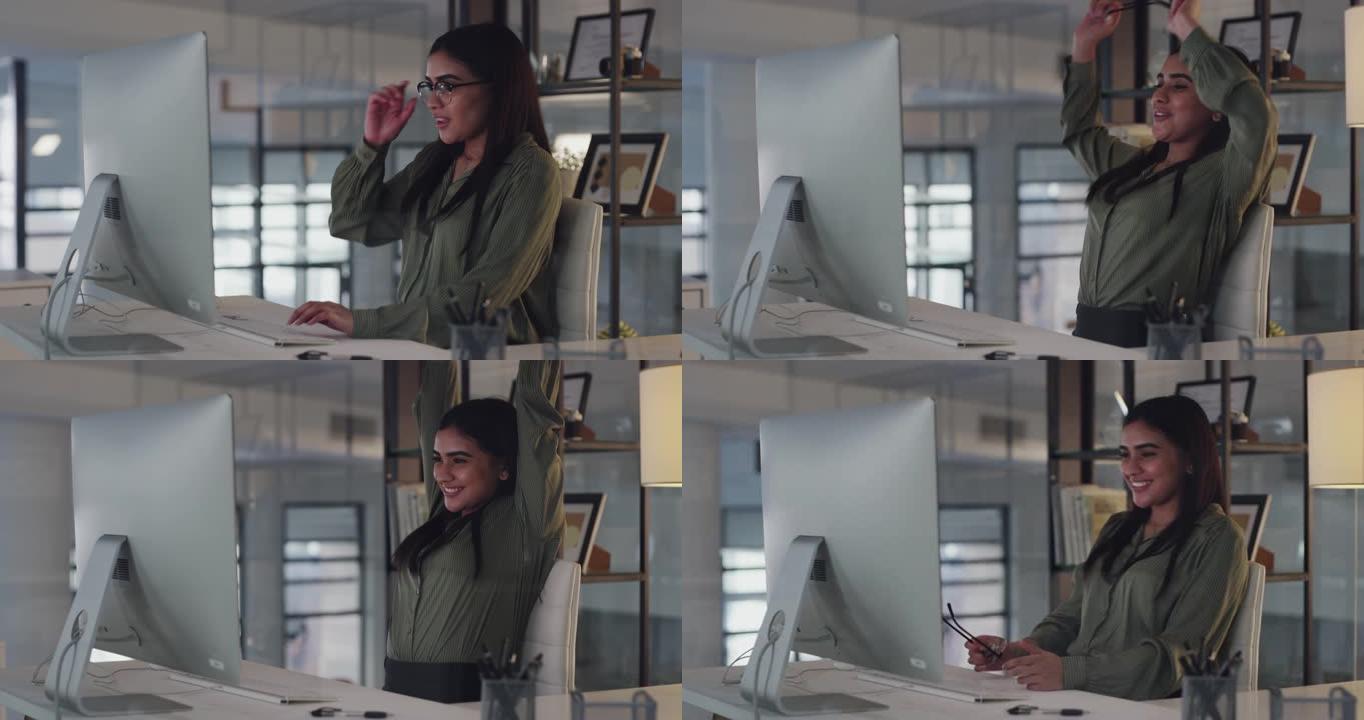 4k视频片段，一位迷人的年轻女商人独自坐在办公室里，在使用计算机时感到放心