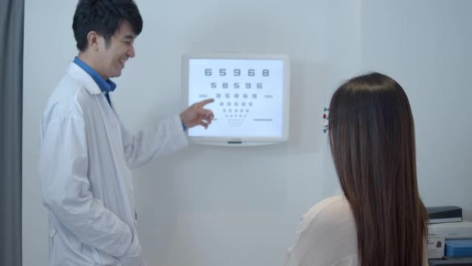 亚洲医生用眼图测试女性患者的视力。