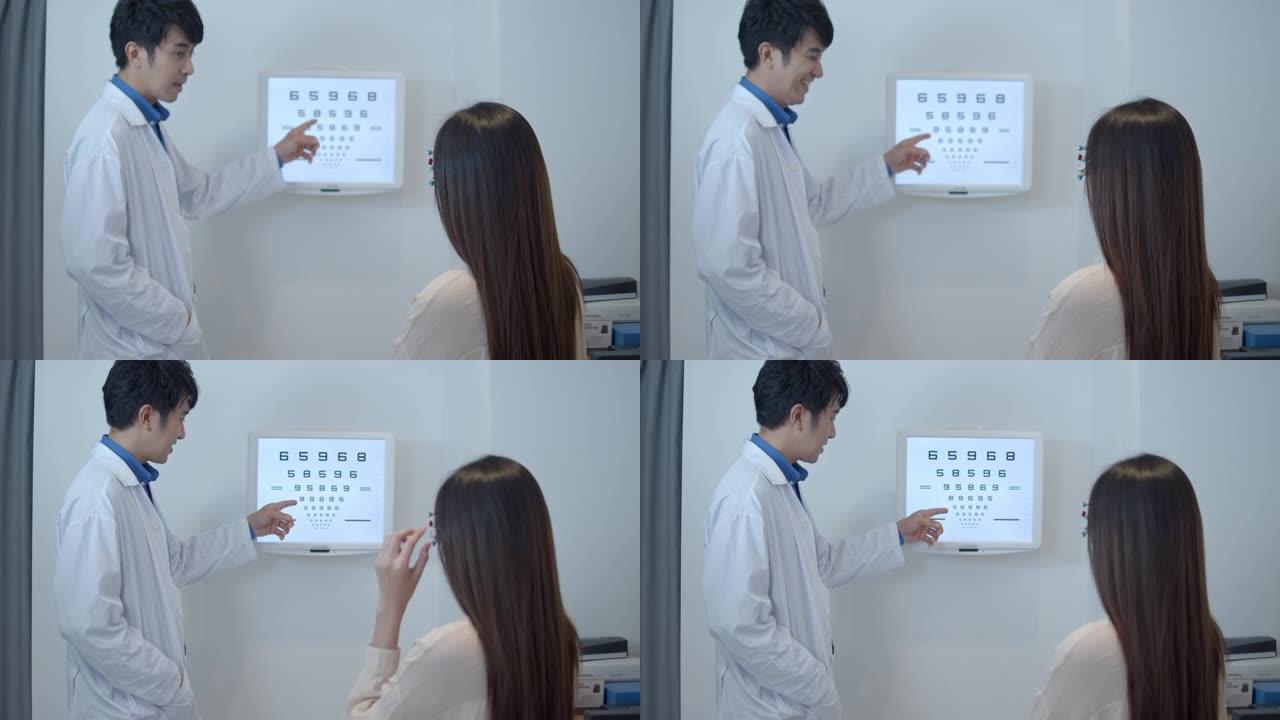 亚洲医生用眼图测试女性患者的视力。