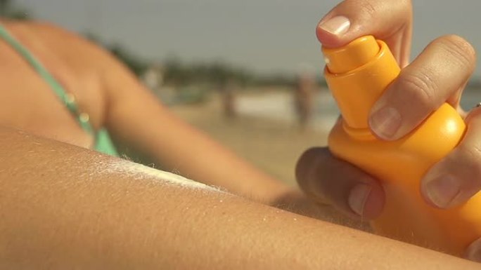 女性在海滩上使用防晒霜