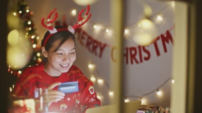 亚洲女性圣诞节晚上在家网上购物