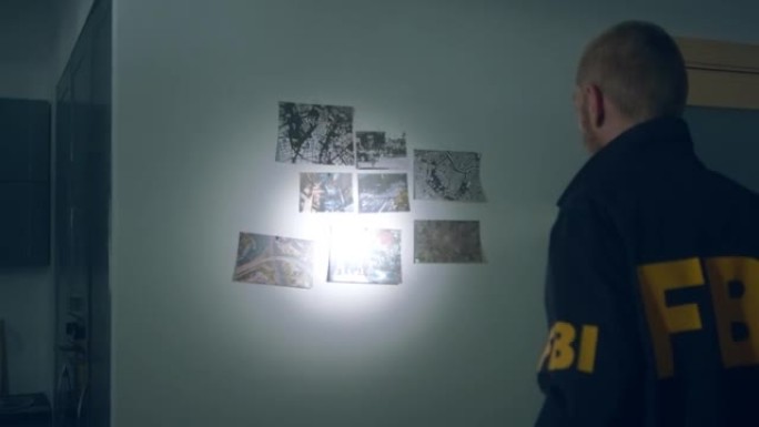 FBI探员在一间黑暗的公寓里拿着手电筒进入犯罪分子的巢穴
