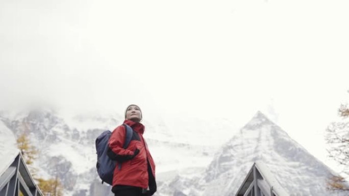 亚洲徒步旅行者爬雪山转身看风景