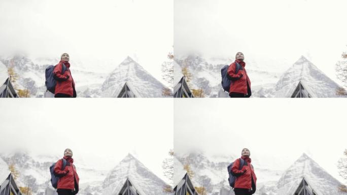 亚洲徒步旅行者爬雪山转身看风景