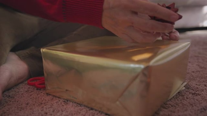 特写亚洲高级女性在家时包装圣诞节礼盒。