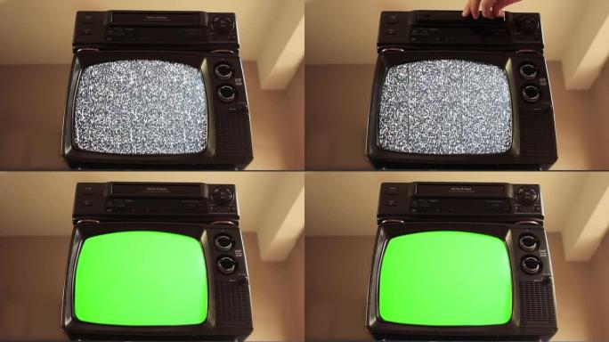 男性手将VHS放入VCR和一台带有绿色屏幕的旧电视。