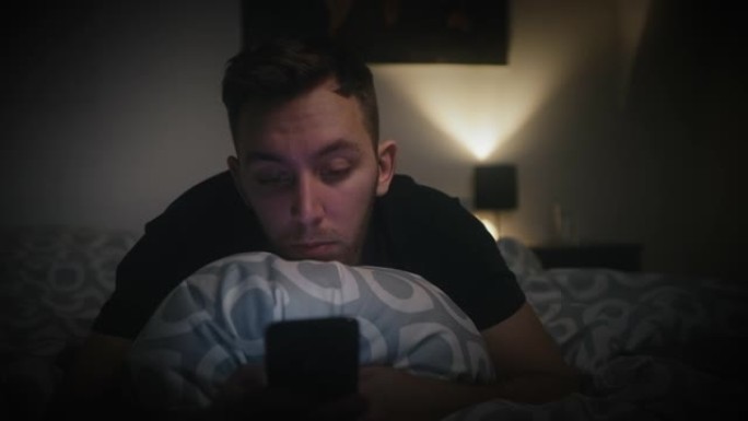 男子深夜在家中床上使用手机