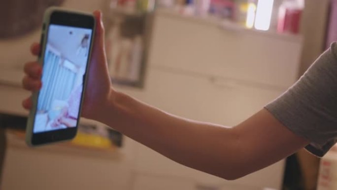 手持拍摄可爱的幼儿，使用智能手机与祖父母进行视频通话