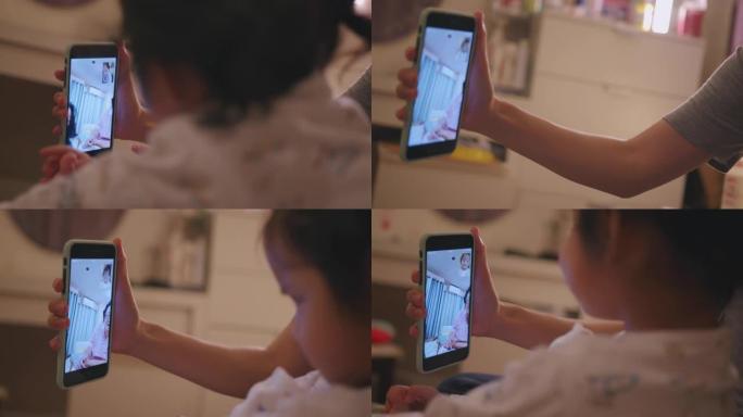 手持拍摄可爱的幼儿，使用智能手机与祖父母进行视频通话