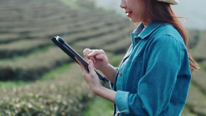 亚洲女性农民使用平板电脑监控和管理田间系统