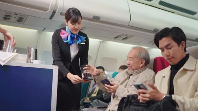 美丽的空姐为乘坐喷气式飞机的老人乘客提供饮料和小吃。