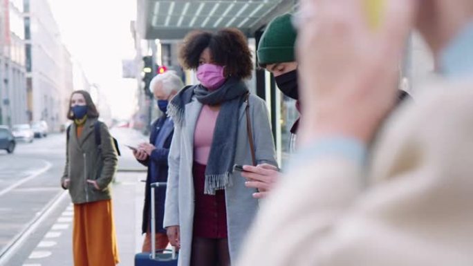 戴着口罩的人在城市运输站等候