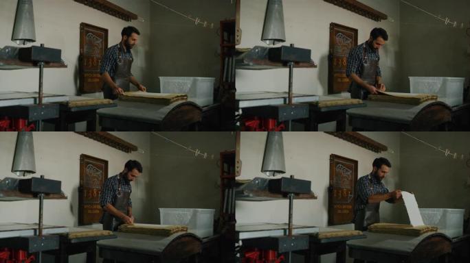 工匠造纸大师的慢动作正在车间生产高质量的手工纸。以8K拍摄。手工制作的概念，高品质，工匠，意大利制造