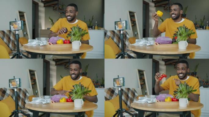 创意男子录制烹饪视频视频，在家中使用智能手机摄像头展示高五手势蔬菜