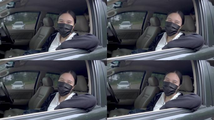 在新型冠状病毒肺炎冠状病毒大流行期间，十几岁的亚洲女孩在汽车上戴着防护口罩微笑，家人在背景下微笑