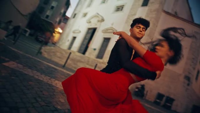 美丽的夫妇在城市老城区的安静街道上跳拉丁舞。晚上，两位专业舞者在古老的文化底蕴丰富的旅游地点进行感性