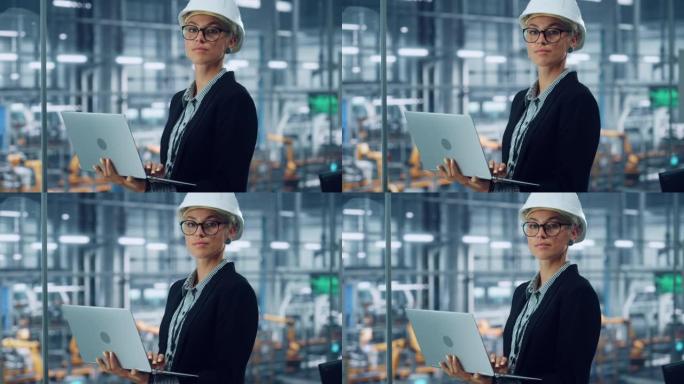 一位微笑的年轻美丽的女工程师戴着白色安全帽，在汽车装配厂的办公室使用笔记本电脑的肖像。在现代设施中从