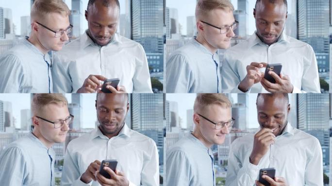 一个黑人在电话屏幕上向他的白人同事显示了一些东西，他们俩都笑了。