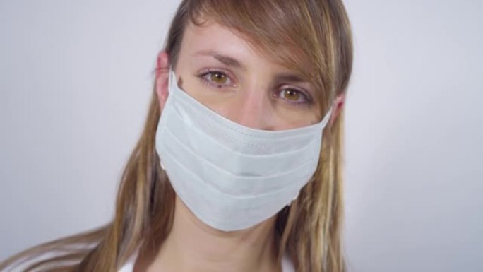 特写: 微笑的护士在实验室里戴上脱去外科口罩。