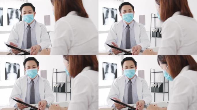 严重的亚洲男性医生戴防护口罩使用平板电脑正在传递重大新闻谈话与医院办公室的女性患者讨论结果或症状。