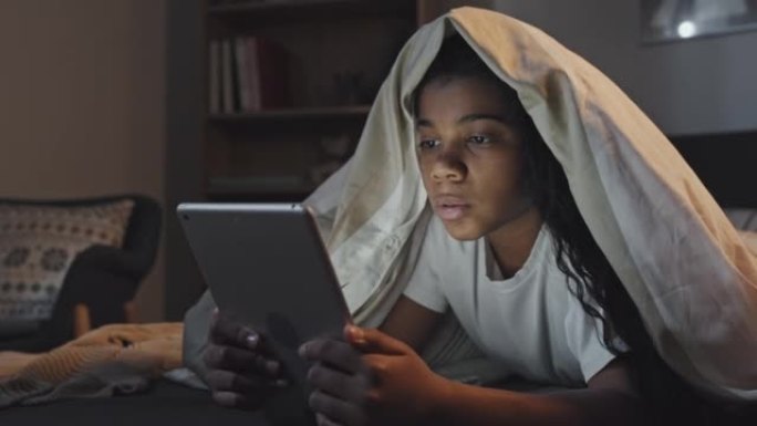 女孩在床上使用平板电脑