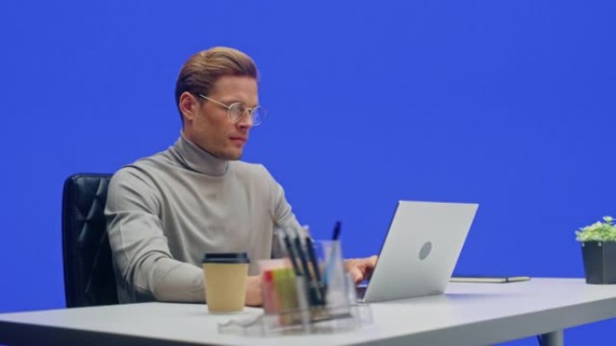 现代办公室绿屏背景: 商人坐在办公桌前在笔记本电脑上工作。从事大数据电子商务分析的人。360度跟踪拍