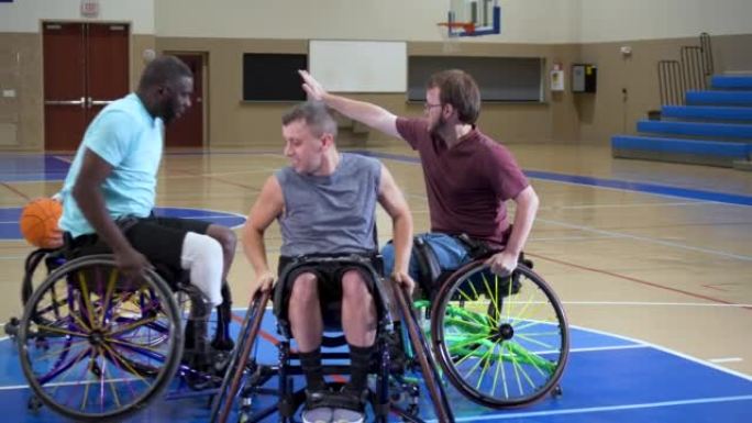 四名男子打轮椅篮球，传球和投篮