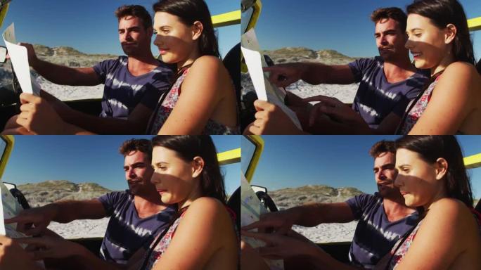 高加索夫妇坐在海边的海滩越野车上阅读地图