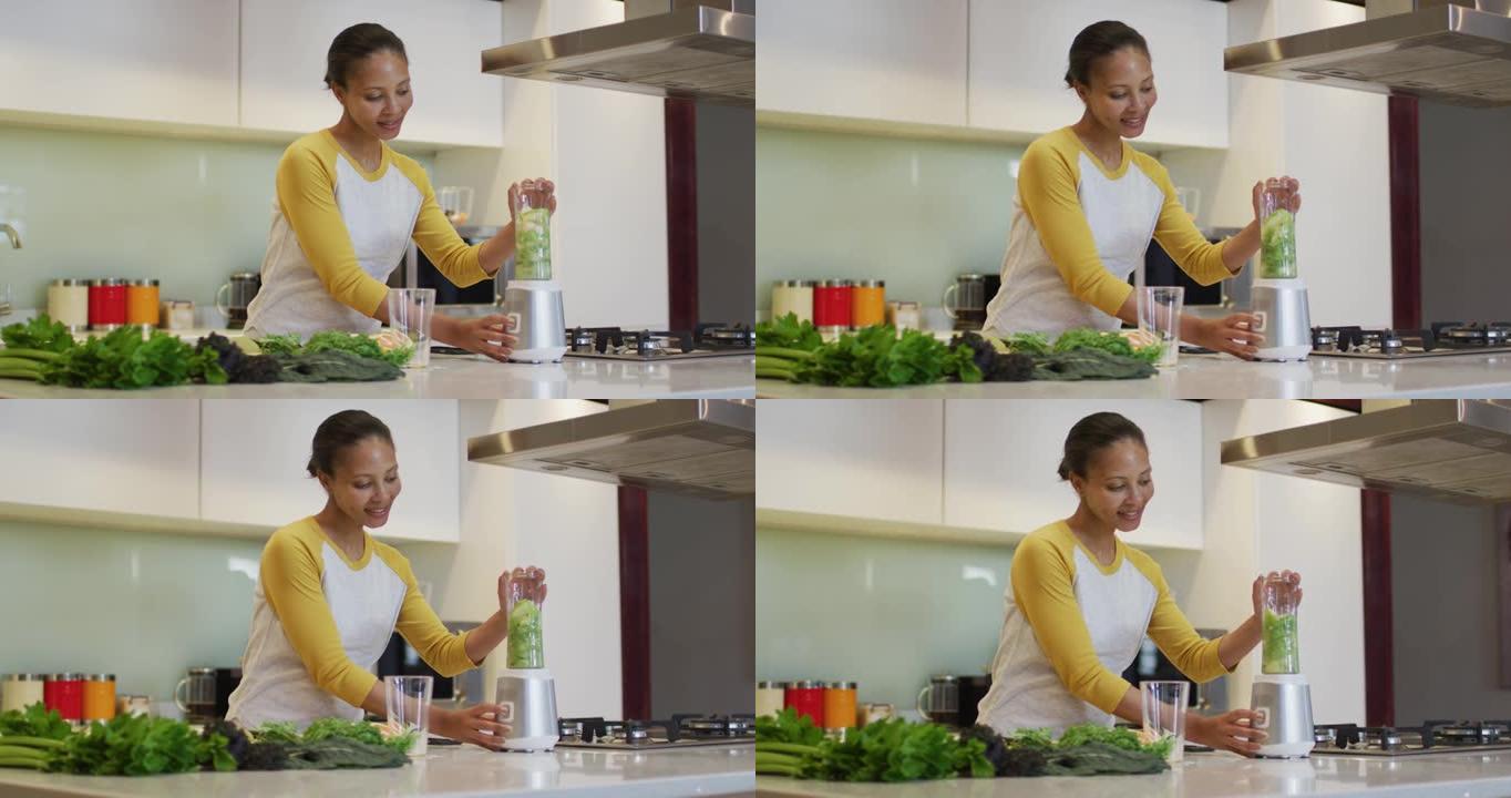 混合种族妇女准备健康饮料，在厨房混合水果和蔬菜