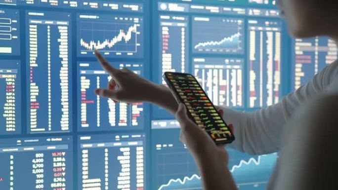 亚洲女性分析数据股市，大型电脑显示器或显示器上的财务数字