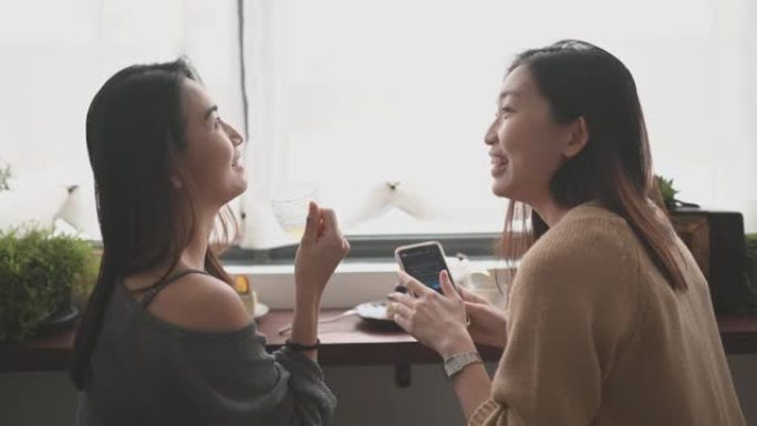 2位中国女性朋友在周末享受下午茶与彼此在咖啡馆分享甜点