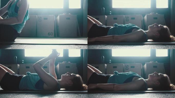 健身追踪器手表应用程序运动的年轻女子躺在带手镯的瑜伽垫上做腹肌练习，观察进步。