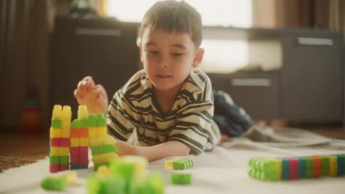 白天，可爱的亚洲男性孩子在房间里玩彩色积木的肖像。创意和专注的小男孩使用逻辑和技能制作玩具屋。他很高