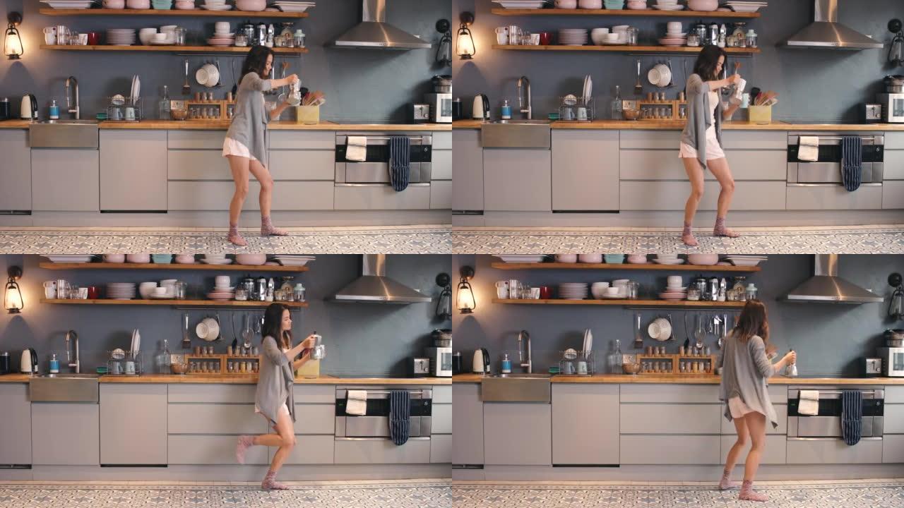 4k视频片段，一名年轻女子在家里的厨房里跳舞时喝咖啡