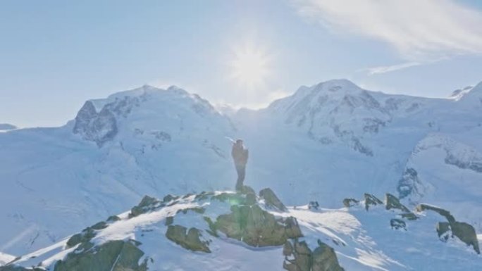 Man操作具有马特宏峰日落背景的无人机遥控器。瑞士阿尔卑斯山。