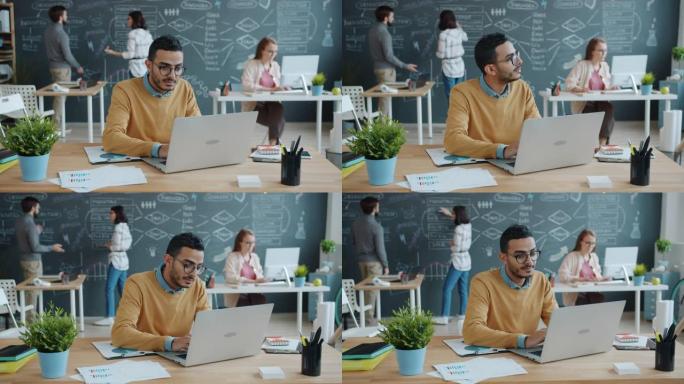 阿拉伯人的慢动作专注于在共享的工作空间中使用笔记本电脑工作