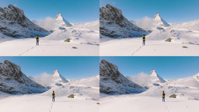 站在瑞士马特宏峰山顶上的旅行者年轻女性的空中无人机视图。大自然中的幸福。具有多样性概念的体验式旅行。