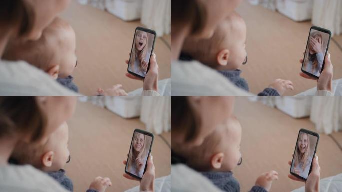母亲和婴儿使用智能手机与最好的朋友视频聊天，向蹒跚学步的快乐妈妈挥手，享受在手机屏幕上分享母亲的生活