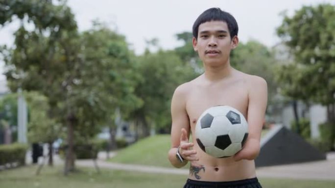 亚洲年轻截肢者在球场上持球的肖像。