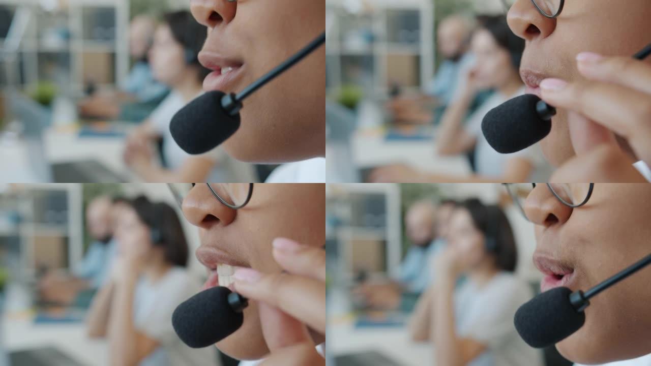 在客户支持服务中工作的非裔美国妇女在麦克风中讲话的特写镜头