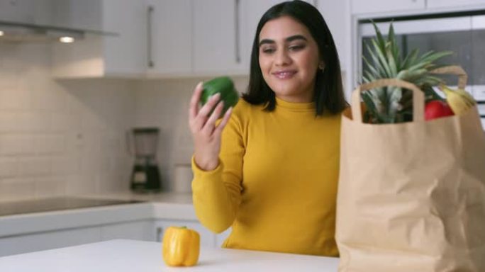 4k视频片段，一名年轻女子从家里厨房的纸袋中打开新鲜农产品的包装
