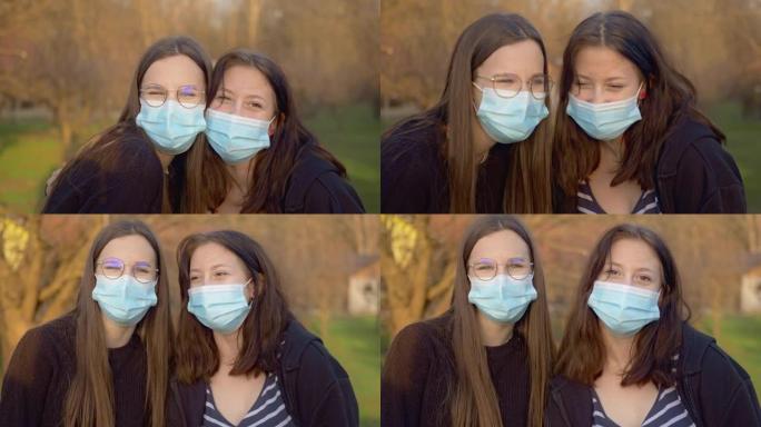 两名十几岁的女孩在户外见面时戴着防护口罩