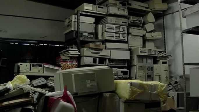 电子计算机堆在黑暗的房间里，废弃的电子设备堆在黑暗的房间里。