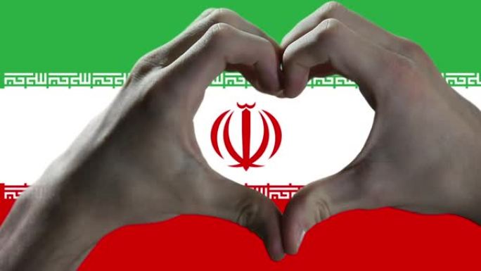 双手在伊朗国旗上显示心脏标志。