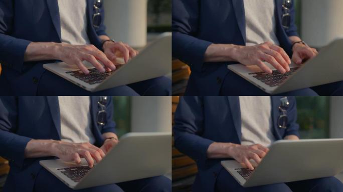 企业家在笔记本电脑上向商业伙伴输入电子邮件的手的特写