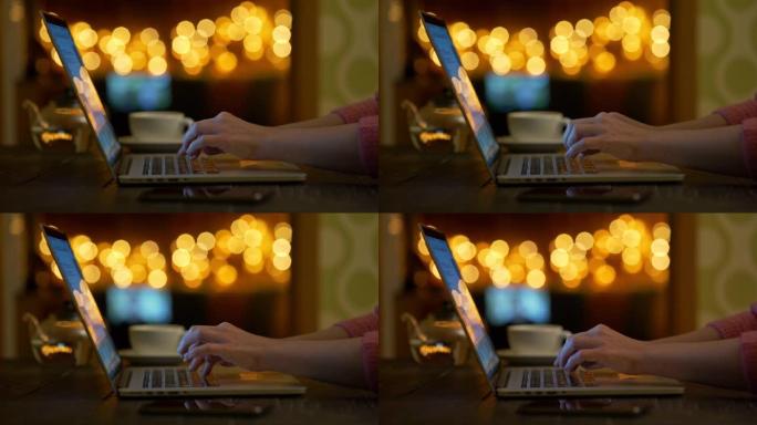 女性手在笔记本电脑上打字。女人在电脑工作或写书。家里或咖啡馆舒适的氛围。背景下温暖的橙色bokeh圆