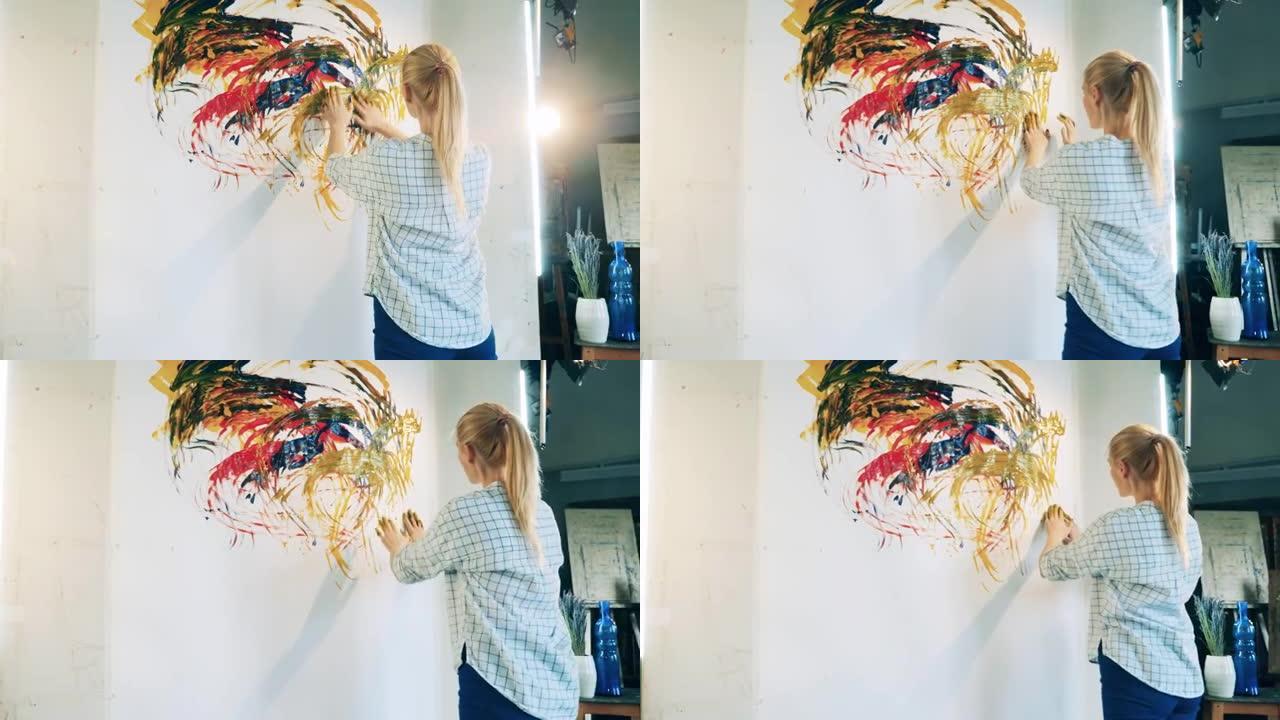金发女士正在赤手空拳地画一幅画。创造，灵感概念。