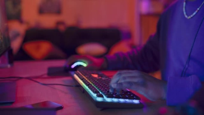 玩家戴上耳机，在电脑上玩在线视频游戏。非裔美国男性享受RPG策略，屏幕显示街机在线多人PvP战斗。关